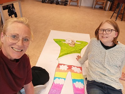 Therapeut en cliënt op de grond bij een tekening tijdens beeldende therapie